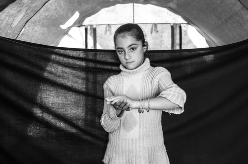 Eight-year-old May in Domiz camp in the Kurdistan Region of Iraq. The girl and her family made their way by foot and bus hundreds of kilometres from Damascus to the border, where they followed a rough trail in the cold while her mother carried her baby brother. Since arriving in Domiz, she has had recurring nightmares. The most important thing she was able to bring with her when she left home is the set of bracelets she wears in this photograph. “The bracelets aren’t my favourite things,” she says, “My doll Nancy is.” She adds that the toy was left behind in the rush to leave.