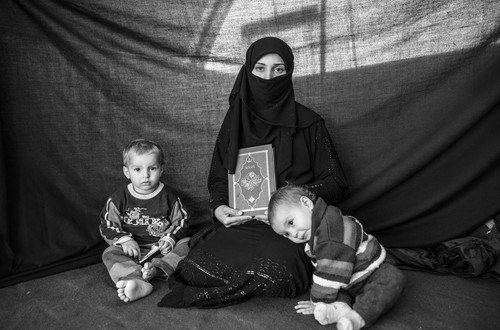 Iman, 25, with her son Ahmed and daughter Aishia, in Nizip refugee camp, Turkey. They fled their home in Aleppo after months of conflict. Iman decided it was time to flee when she heard accounts of sexual harassment against women in Aleppo. The journey to Turkey was full of danger – Iman lost five relatives. The most important thing she was able to bring with her is the Koran she holds in this photograph. She says the Koran inspires a sense of protection. “As long as I have it with me, I’m connected to God.”