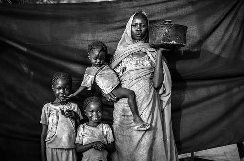 Magboola, 20, and her family weathered air raids for several months, but decided it was time to leave their village of Bofe the night that soldiers arrived and opened fire. With her three children, she travelled for 12 days from Bofe to the town of El Fudj, on the South Sudanese border. The most important thing she was able to bring with her is the cooking pot she holds in this photograph. It was small enough she could travel with it, yet big enough to cook sorghum for herself and her three daughters during their journey. Jamam refugee camp, Maban County, South Sudan.